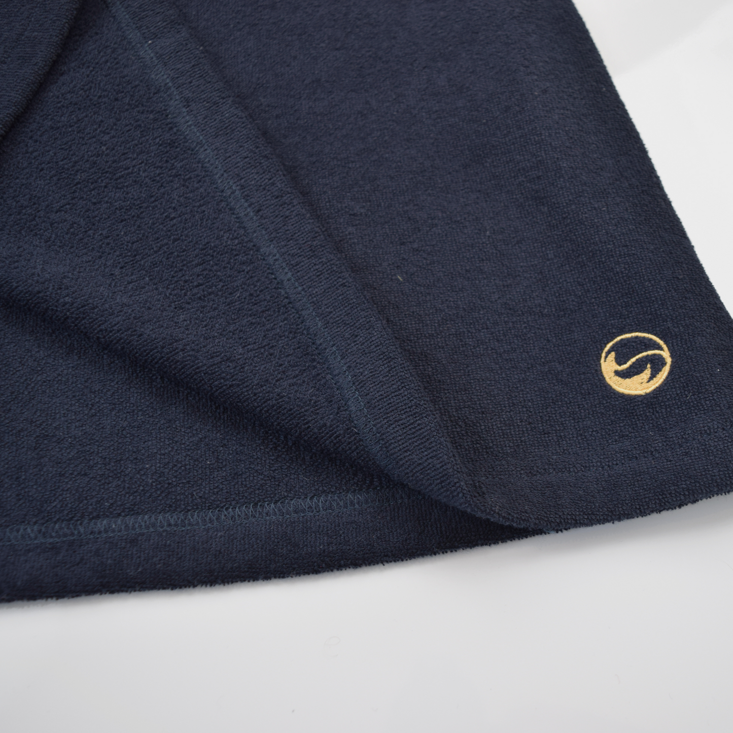 Navy fabric with a gold logo on a white background
